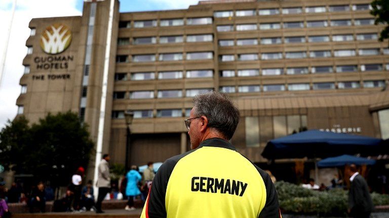 A member of Germany"s athletics squad stands by the Tower Hotel in London