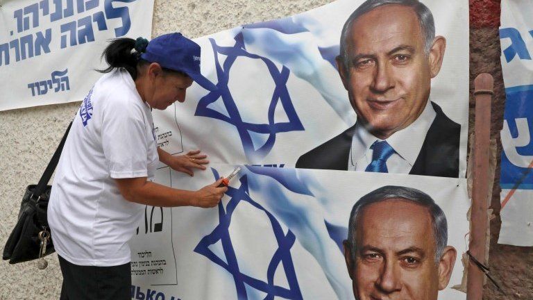 Woman puts up campaign posters for Benjamin Netanyahu in Beersheba (15/09/19)