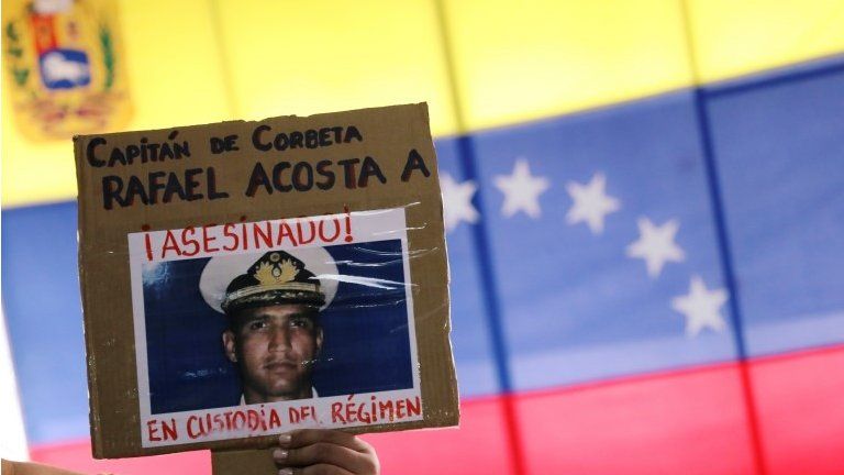 A woman shows a placard with a picture of Rafael Acosta, a navy captain who died while in detention according to his wife, after a news conference in Caracas, Venezuela July 4, 2019