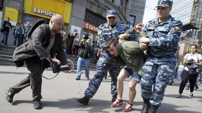 Russian police detain a protester at an unapproved rally in Moscow, 7 May