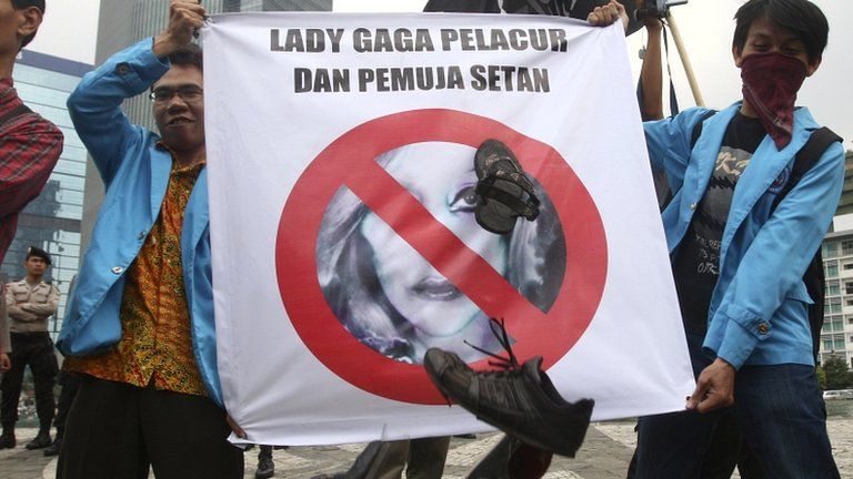 Protesters throw shoes at a defaced poster of US pop singer Lady Gaga in Jakarta on 24 May 2012