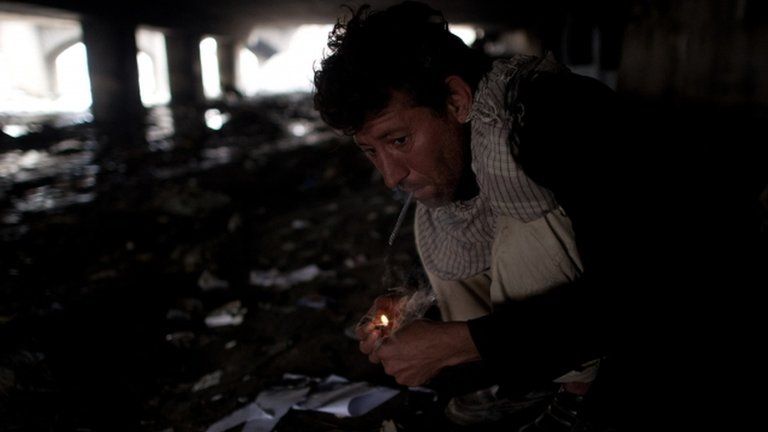 A man smokes heroin under a bridge in Kabul, Afghanistan 25 April 2012