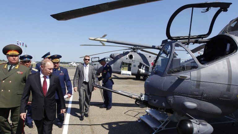 Russia's President Vladimir Putin (2nd L) looks at Mi-24 ground-attack helicopters as he visits a military airbase in the city of Korenovsk June 14, 2012