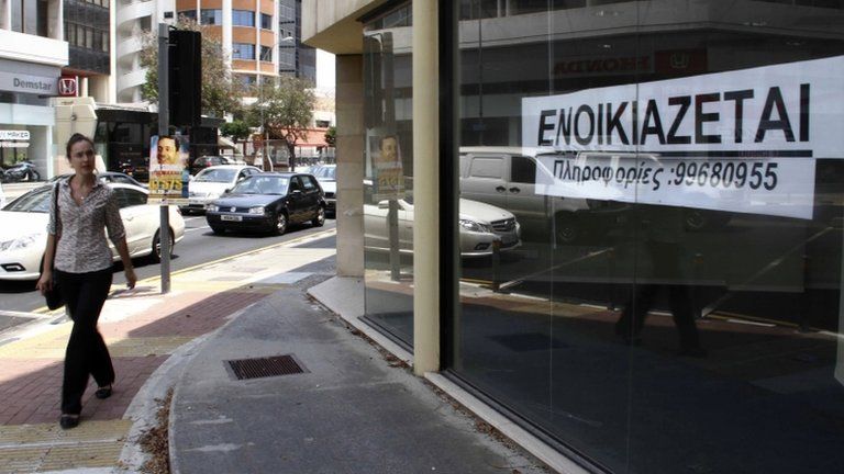 A woman passes a shop for rent in Nicosia, Cyprus, 26 June