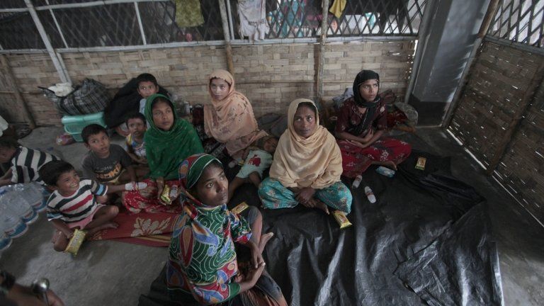 Rohingya Muslim people fled from Myanmar sit as they are held in a temporary shelter at a camp of Border Guards of Bangladesh (BGB) before their repatriation back to Myanmar, in Taknaf, Bangladesh, Friday, June 22, 2012