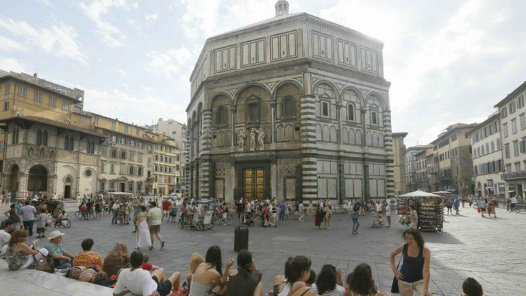 People sit near the Baptistery of San Giovanni in Florence, 26 June 2012