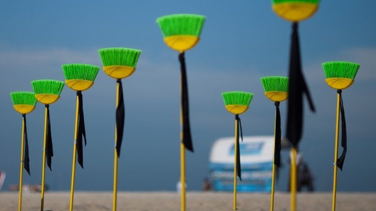 A row of brooms set into the sand as a protest against political corruption at Copacabana beach, Rio de Janeiro, Brazil, 10 July 2012