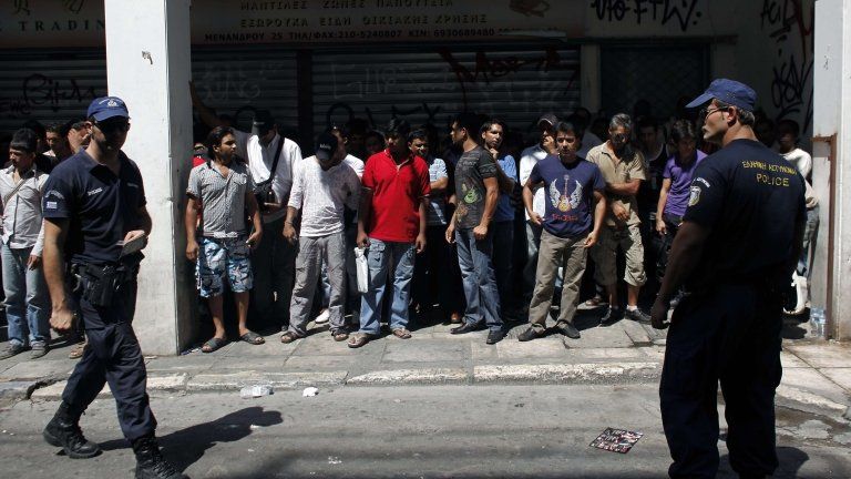 Police detain a group of immigrants in central Athens on August 5, 2012