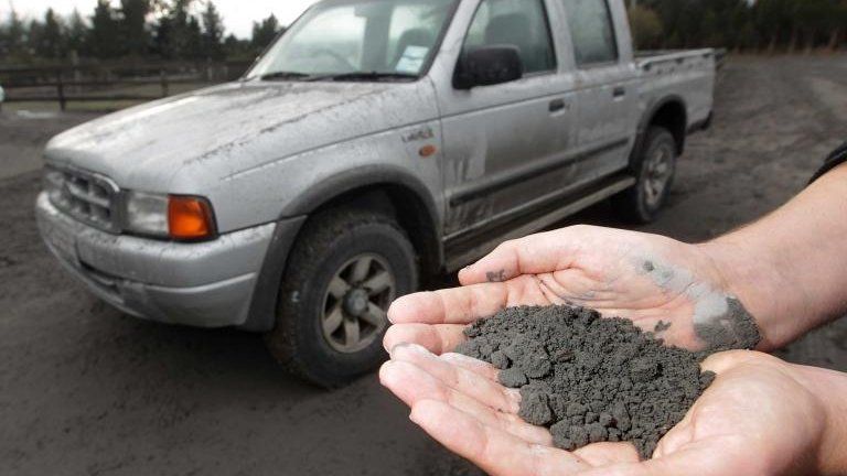 A man holds a handful of volcanic ash that fell on a property in Rangipo near the base of Mt Tongariro, New Zealand after an eruption 7 August, 2012