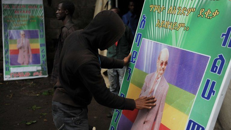 A man prays in front of a poster of late Ethiopian leader Meles Zenawi, Addis Ababa (22 Aug 2012)