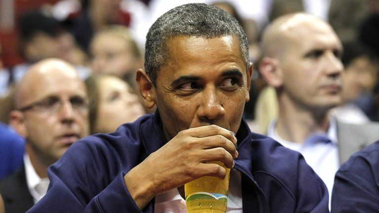 President Barack Obama drinks a beer at a basketball game in Washington DC on 16 July 2012