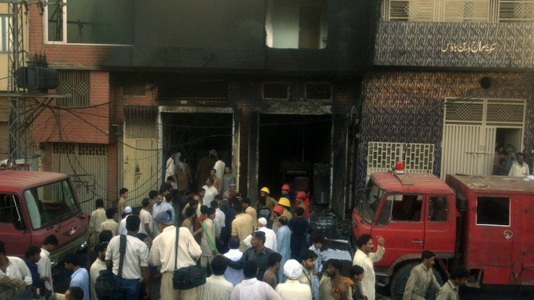 People gather outside the Lahore factory
