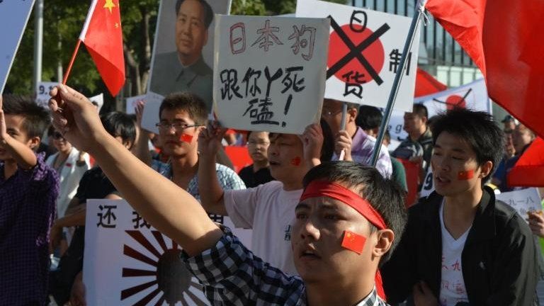 Demonstrators march outside the Japanese embassy in Beijing as anti-Japanese protests continue across the country over the Diaoyu islands issue, known as the Senkaku islands in Japanese, on 18 September, 2012