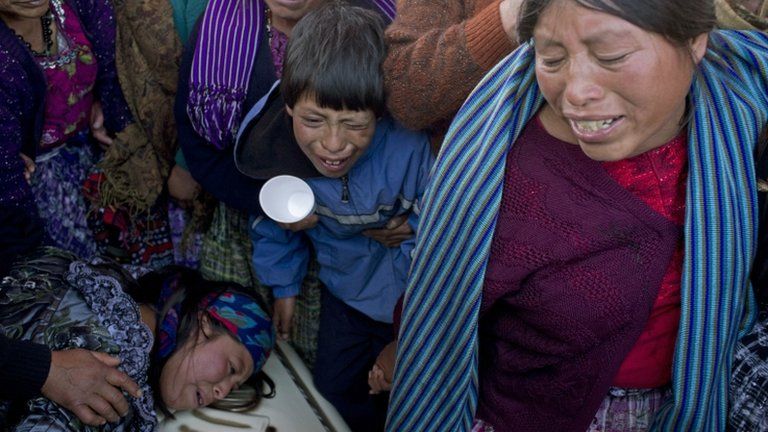Relatives weep over the coffin containing the remains of Francisco Ordonez during a mass funeral service in Totonicapan, Guatemala