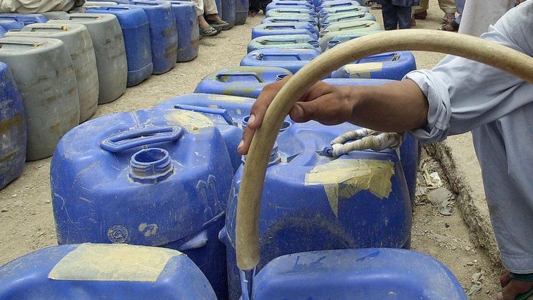 Man filling jerry cans with water
