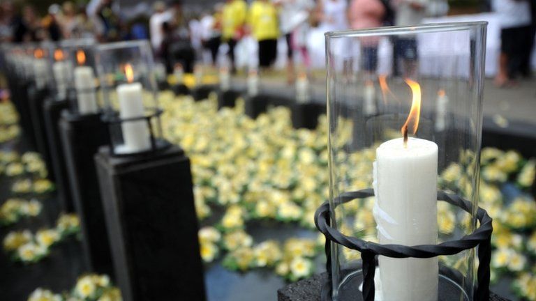 Survivors and relatives of victims of the blasts lay flowers at the pool of remembrance during a ceremony in Bali on 12 October 2012
