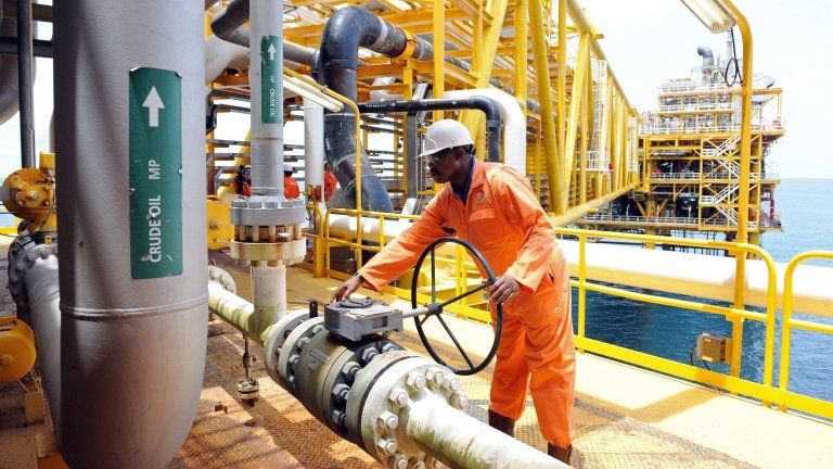 A file photo taken on April 14, 2009 shows a worker inspecting facilities on an upstream oil drilling platform at the Total oil platform at Amenem, 35 kilometres away from Port Harcourt, Nigeria.