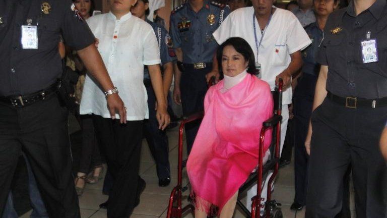 Former Philippine President Gloria Macapagal Arroyo, now a sitting lawmaker in the lower house of Congress, sits on a wheelchair on her way towards the Sandiganbayan anti-graft court in Quezon City, Metro Manila 29 October, 2012
