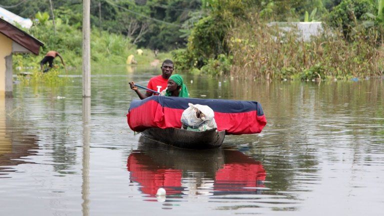 A man and his wife paddle a canoe with their belongings after flooding in the Amassoma community in Bayelsa state October 5, 2012.