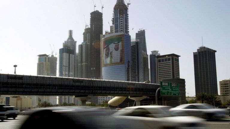 Cars pass by a picture of the prime minister and president of the UAE at Internet City in Dubai (file)