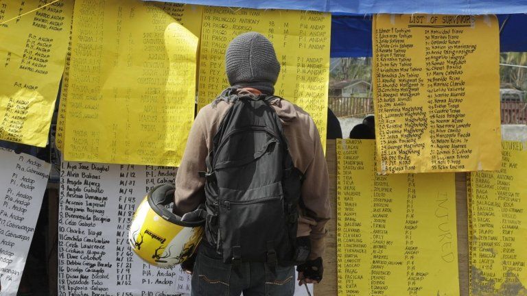 Man looks at list of missing people in New Bataan, Philippines, 12 December 2012