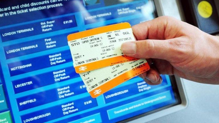 Rail tickets held out in front of ticket machine