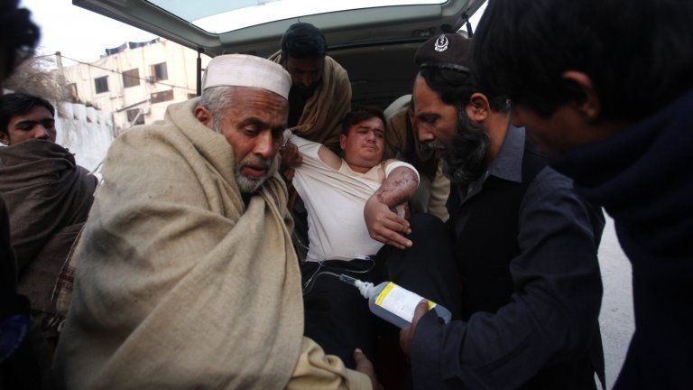 An injured driver (in white) who survived a shooting by unidentified gunmen in Swabi, arrives at the Lady Reading Hospital in Peshawar January 1, 2013