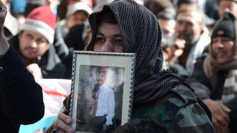 A Pakistani Shiite Muslim holds picture of bomb blast victim at a protest in Quetta