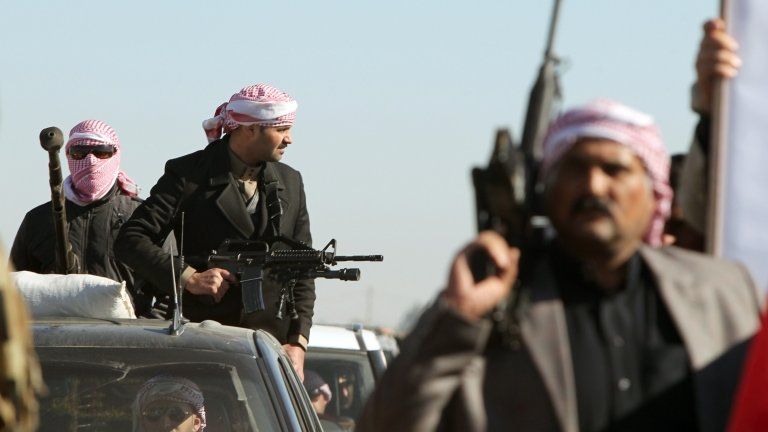 Armed supporters of the Sunni MP Eifan Saadoun al-Issawi accompany his funeral cortege in Fallujah on Wednesday