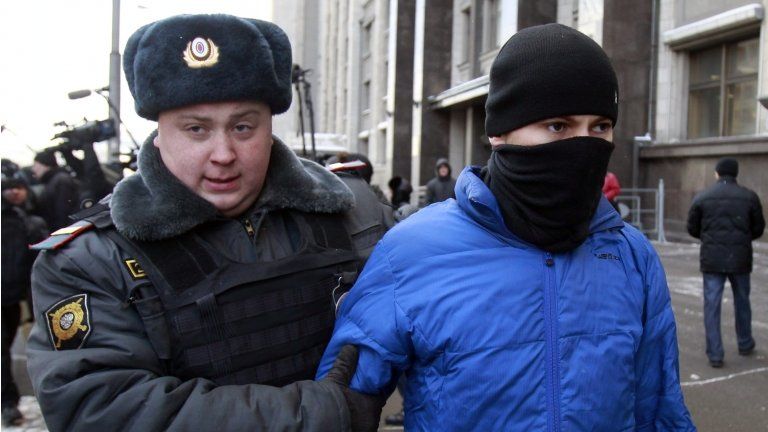 A Russian policeman detains a man who attacked gay rights campaigners outside the State Duma in Moscow, 25 January
