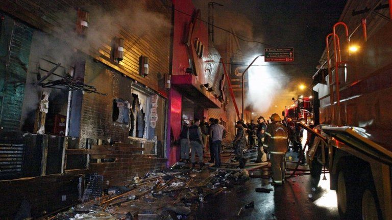 Firefighters try to put out a fire at a nightclub in Santa Maria