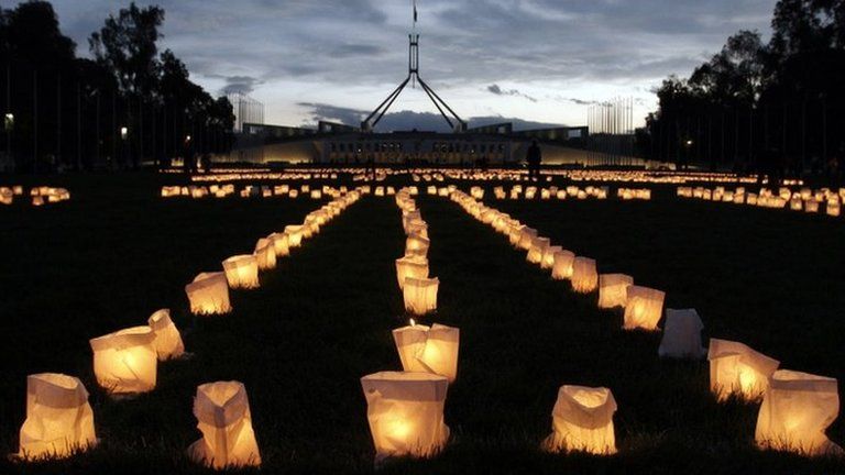 Candles laid out to read sorry glow outside of Parliament House on 11 February 2008 in Canberra, Australia