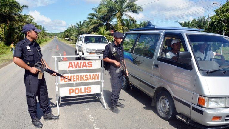 Malaysian policemen check a vehicle near Lahad Datu in Sabah on 14 February 2013