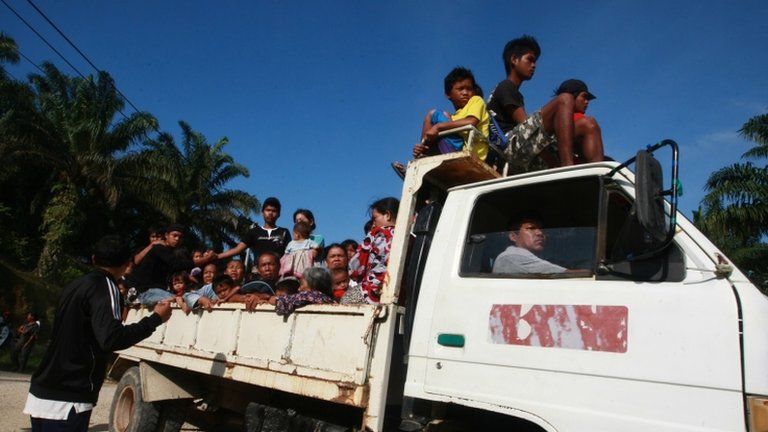 Residents leave their village in Tanjung Labian near Tanduo, where Malaysia launched airstrikes and mortar attacks against nearly 200 Filipinos occupying a Borneo coastal village on 5 March 2013