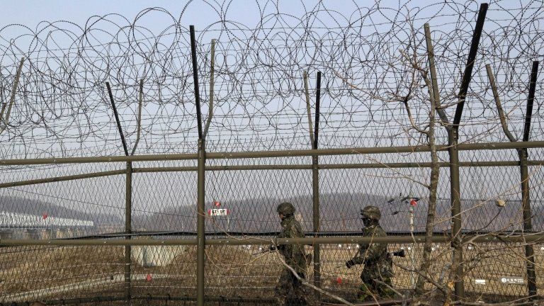 South Korean army soldiers patrol along a barbed-wire fence at the Imjingak Pavilion near the border village of Panmunjom, which has separated the two Koreas since the Korean War, in Paju, north of Seoul, South Korea, 6 March 2013