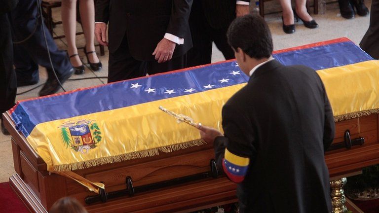 Venezuela's new Acting President Nicolas Maduro places Simon Bolivar's sword on Hugo Chavez's coffin