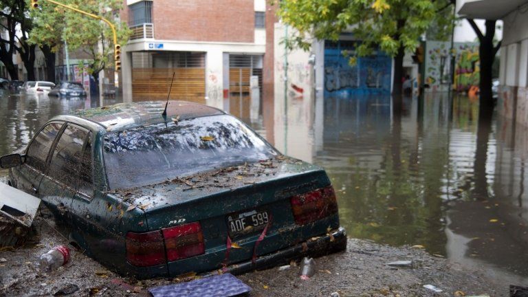 A car floats in a flooded Buenos Aires street