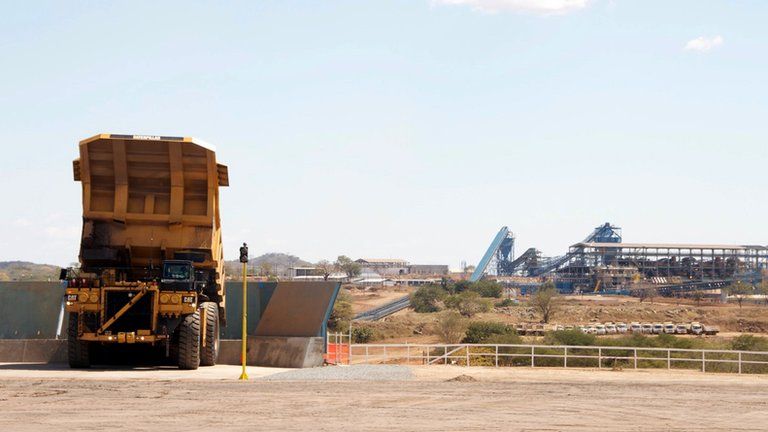 large mine truck dumps a load of coal onto a conveyer belt, in Moatize in northern Mozambique