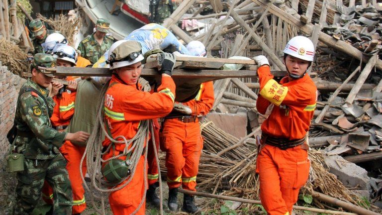 Chinese rescuers carry an injured person in Lushan county. Photo: 20 April 2013