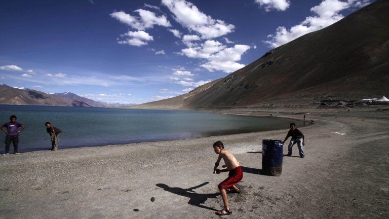 In this July 22, 2011 file photo, children play cricket near Pangong Lake, near the India-China border in Ladakh, India.