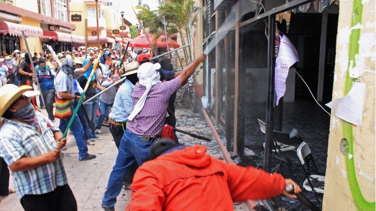 A group of teachers attack the ruling PRI party's local offices during a protest against the education reform in Chilpancingo, Guerrero state, Mexico, on Wednesday