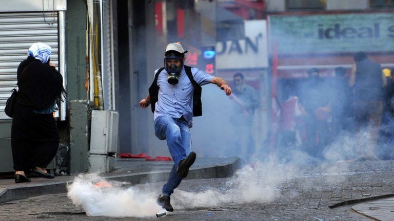 A protester kicks away a tear gas canister in Istanbul, Turkey, 1 May