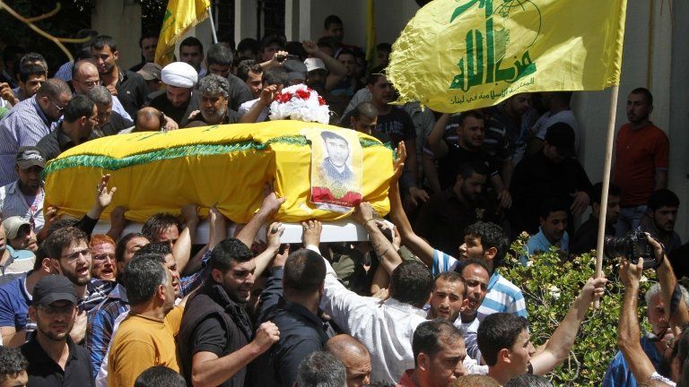 Men carry the coffin of a Hezbollah member allegedly killed while fighting in the Syrian town of Qusair, during his funeral in Beirut, Lebanon (22 May 2013)