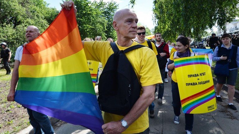Activists carry a rainbow flag during a gay pride march in Kiev. Photo: 25 May 2013