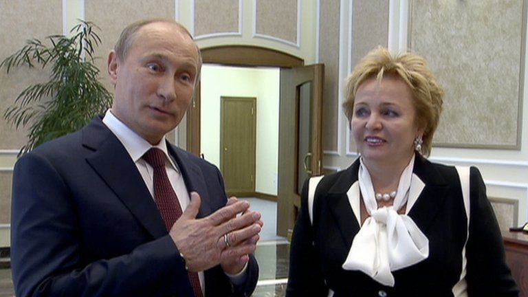 Russian President Vladimir Putin, left, and his wife Lyudmila speak to journalists on Russian TV