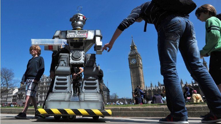 People look at a mock "killer robot" in central London - part of a protest calling for a ban on such weapons in London on 23 April 2013