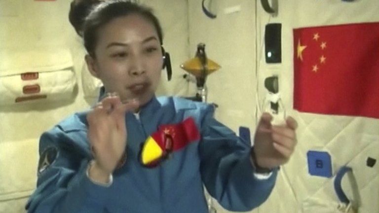 Chinese female astronaut Wang Yaping shows motion behaviour of two spinning objects in micro-gravity during the broadcast live from onboard the Tiangong 1 prototype space station, 20 June 2013
