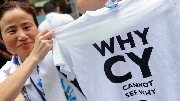 A protester holds a T-shirt during a rally for democracy in Hong Kong on 1 July 2013