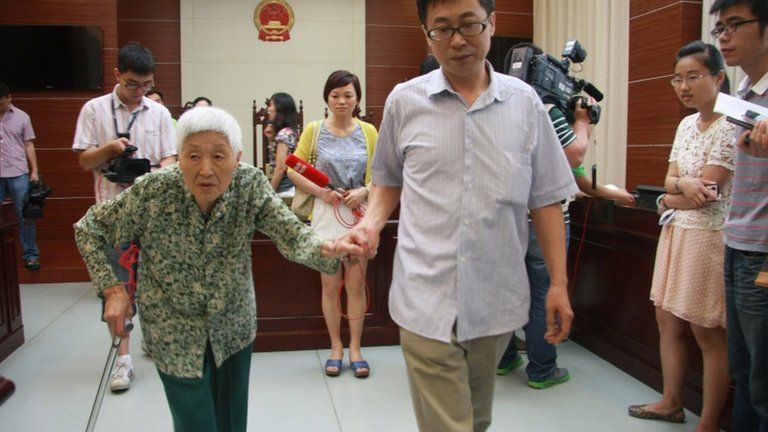 This 1 July picture shows a woman surnamed Chu (L), 77, attending the hearing of a case against her daughter and husband in Wuxi, east China's Jiangsu province.