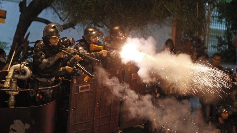 Police fire rubber bullets at demonstrator during clashes near Guanabara Palace in Rio on 22 July 2013